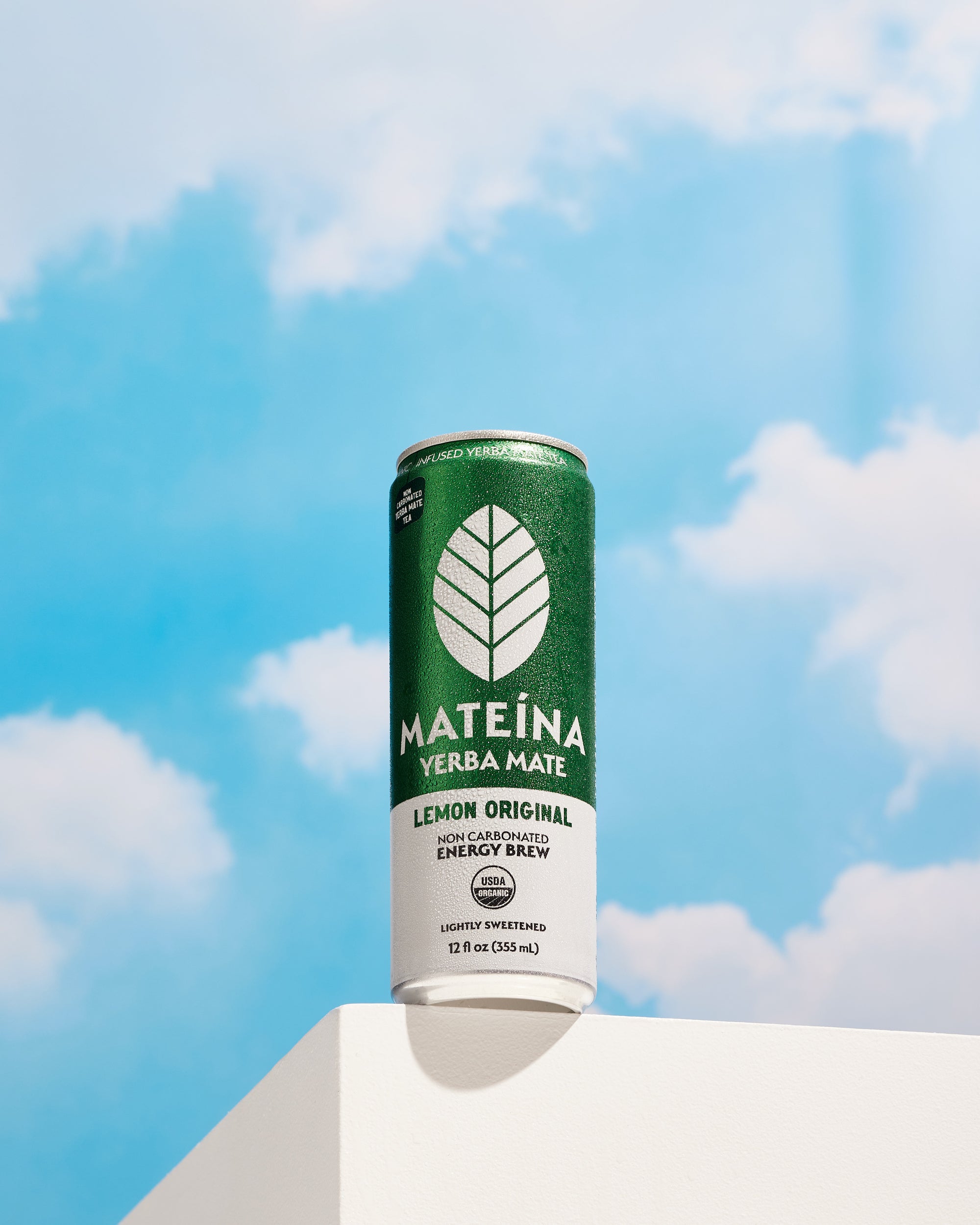 Mateina Energy Brew - Lemon Original can against a bright blue sky, showcasing refreshing yerba mate flavors.